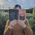 Femme tenanit le livre Si ça saigne de Stephen King devant son visage
